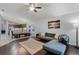Open concept living room with hardwood floors, ceiling fan, modern sofa, and dining area at 13826 Mirror Lake Dr, Orlando, FL 32828