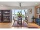 Bright dining room with water view, ceiling fan, hardwood floors, area rug, and decorative bookcase at 151 N Orlando Ave # 212, Winter Park, FL 32789