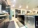 Stylish kitchen featuring stainless steel appliances, dark cabinetry, and tile flooring at 16611 Toccoa Row, Winter Garden, FL 34787