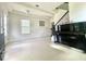 Bright and airy living room with staircase, grand piano, white tile flooring, and large windows at 16611 Toccoa Row, Winter Garden, FL 34787