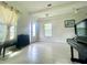 Comfortable living area featuring tile floors, bright windows, stylish curtains, and a grand piano at 16611 Toccoa Row, Winter Garden, FL 34787
