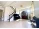 Spacious living room with tile floors, chandelier, and staircase featuring iron balusters and a grand piano at 16611 Toccoa Row, Winter Garden, FL 34787