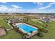 Aerial view of a pool with lounge chairs in a community with houses being built in the background at 189 Luxmore Rd, Groveland, FL 34736