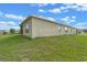 Backyard with lush green lawn and views of the home's exterior with neutral siding and several windows at 189 Luxmore Rd, Groveland, FL 34736