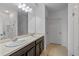 Bathroom featuring dual sinks, dark wood cabinets, neutral tile flooring, and glass-enclosed shower at 189 Luxmore Rd, Groveland, FL 34736