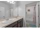 Well-lit bathroom with double sinks, dark cabinets, and a separate toilet and shower area at 189 Luxmore Rd, Groveland, FL 34736