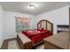 Bright bedroom with a large window, a padded headboard, and an attractive red floral bedspread at 189 Luxmore Rd, Groveland, FL 34736