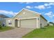 Single-story home with brick driveway, two-car garage, and landscaped front yard for a warm welcome at 189 Luxmore Rd, Groveland, FL 34736