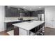 Modern kitchen features dark wood cabinets, stainless steel appliances and a large island with seating at 189 Luxmore Rd, Groveland, FL 34736