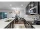 Open kitchen and dining area with dark wood cabinets, stone countertops, stainless appliances and stylish decor at 189 Luxmore Rd, Groveland, FL 34736