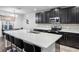 Stylish kitchen boasts dark cabinetry, stainless steel appliances, and a spacious island with bar stool seating at 189 Luxmore Rd, Groveland, FL 34736
