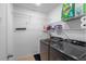 Laundry room includes a washer, dryer, and storage shelves, for efficient organization and cleaning at 189 Luxmore Rd, Groveland, FL 34736