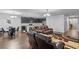 Open-concept living room features wood floors, brown leather recliners, modern lighting and adjoins the kitchen at 189 Luxmore Rd, Groveland, FL 34736