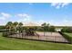 View of a playground with a sunshade, swings, slides and a mulch base surrounded by grass at 189 Luxmore Rd, Groveland, FL 34736