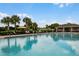 View of a pool with lounge chairs and palm trees at a community center and golf course at 189 Luxmore Rd, Groveland, FL 34736