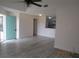 Bright living room with updated floors, ceiling fan, and an open view into the kitchen area at 2002 Cascades Blvd # 201, Kissimmee, FL 34741