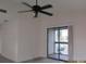 Bright living room with sliding glass door to balcony and a ceiling fan at 2002 Cascades Blvd # 201, Kissimmee, FL 34741