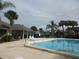 A community pool and clubhouse with palm trees and chairs for relaxing in a beautiful serene community at 2002 Cascades Blvd # 201, Kissimmee, FL 34741