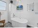 Bright bathroom boasts a modern soaking tub with a TV and elegant light fixture at 204 Cotswold Cir, Davenport, FL 33837