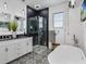 Modern bathroom featuring a stand-alone tub, glass shower and double vanity sinks at 204 Cotswold Cir, Davenport, FL 33837