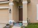 Inviting front entrance with a dark wood door, potted plants, and exterior lighting at 204 Cotswold Cir, Davenport, FL 33837