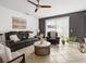 Cozy living room featuring tile flooring, a comfortable sofa, and neutral decor at 204 Cotswold Cir, Davenport, FL 33837