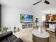 Bright living room featuring a large TV, decorative plants, and stylish furniture at 204 Cotswold Cir, Davenport, FL 33837