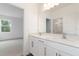 Bright bathroom featuring double sinks, white cabinetry, and a large mirror reflecting the adjacent bedroom at 2261 Sirena Ln, Mount Dora, FL 32757