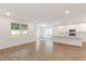 Open-concept living room with a large window and adjacent kitchen with white cabinets and quartz countertops at 2261 Sirena Ln, Mount Dora, FL 32757