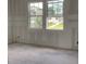 Unfinished room features two windows letting in natural light, taped drywall ready for paint and flooring at 2379 Broadbrook Drive, St Cloud, FL 34771