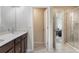 Bathroom with double vanity sinks, wood cabinetry, and a tiled walk-in shower at 2696 Giardino Loop, Kissimmee, FL 34741