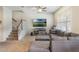 Comfortable living room featuring a large sectional sofa, ceiling fan, and a staircase to the upper level at 2696 Giardino Loop, Kissimmee, FL 34741