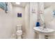 Comfortable powder room featuring pedestal sink, round mirror and beach-themed decor at 2696 Giardino Loop, Kissimmee, FL 34741