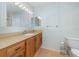 Bright bathroom featuring a large mirror with vanity lighting, wood cabinets, and tile flooring at 300 Carolina Ave # 205, Winter Park, FL 32789