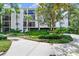 Exterior view of a white condo building with lush landscaping and a sidewalk at 300 Carolina Ave # 205, Winter Park, FL 32789