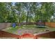 Large fenced backyard featuring a trampoline and lush greenery offers ample space for outdoor activities at 30926 County Road 435, Sorrento, FL 32776