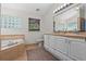 Bright bathroom offers a soaking tub, double sink vanity, and tile floor at 30926 County Road 435, Sorrento, FL 32776