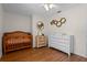 Bedroom with modern wooden crib and white dresser with a wood floor at 30926 County Road 435, Sorrento, FL 32776