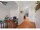 Hallway with hardwood floors, neutral walls, and a view into an adjacent room with a play area at 30926 County Road 435, Sorrento, FL 32776