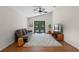 Cozy living room featuring hardwood floors, a comfortable sofa, and double doors leading to the outside at 30926 County Road 435, Sorrento, FL 32776