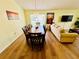 Dining room with a large table and seating for eight, adjacent to the living room with wood-look floors at 318 Langham Dr, Davenport, FL 33897