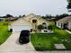 Charming single-Gathering home with a well-maintained lawn, a two-car garage, and lush landscaping at 318 Langham Dr, Davenport, FL 33897