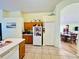Bright and spacious kitchen with ample storage, white appliances, tile floors, and an open view to the dining area at 318 Langham Dr, Davenport, FL 33897