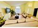 This living room features bright, neutral walls, laminate floors, and comfortable seating with large windows at 318 Langham Dr, Davenport, FL 33897