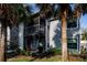 View of the condo featuring a screened-in patio with outdoor furniture and lush landscaping at 3748 Idlebrook Cir # 202, Casselberry, FL 32707