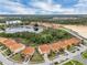 Aerial view of homes with red-tiled roofs, nestled around a tranquil lake and lush greenery at 391 Cabello Dr, Davenport, FL 33837
