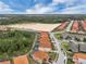 Real estate showcasing red-tiled roofs of homes with backyard pools adjacent to lush greenery at 391 Cabello Dr, Davenport, FL 33837