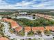 Community view of red-tiled roofs, a lake, and lush greenery, offering a serene and picturesque setting at 391 Cabello Dr, Davenport, FL 33837