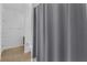 Bathroom showcasing a gray shower curtain, white toilet and a vanity with cabinets at 391 Cabello Dr, Davenport, FL 33837