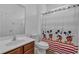 Bright bathroom with a single sink vanity, toilet and a whimsical Mickey Mouse themed shower curtain at 391 Cabello Dr, Davenport, FL 33837